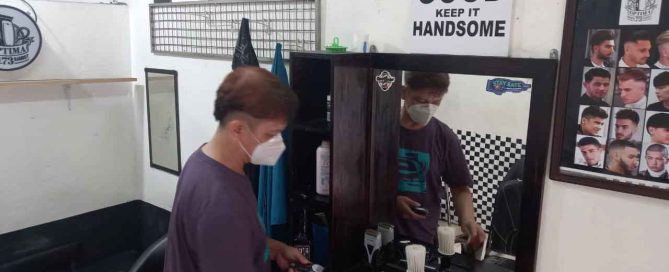 Ageng Patmoko providing barber services