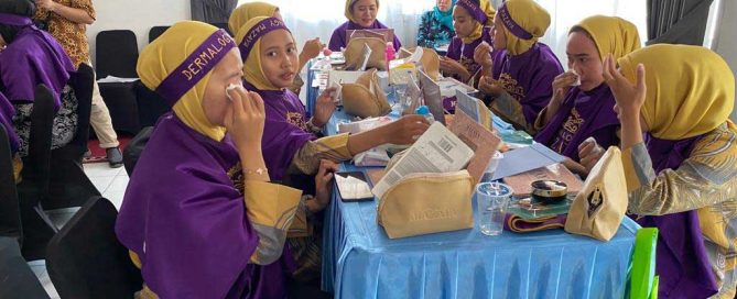 Women practise makeup techniques during the Carenang training