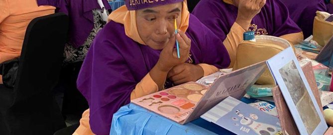 Participants practise makeup techniques during skills training in Carenang