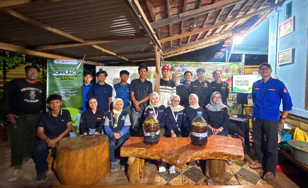 Praktik Pembuatan Eco Enzyme Karang Taruna Bersama Komunitas Koppling Kader Karang Taruna dan fasilitator memegang galon fermentasi eco enzyme