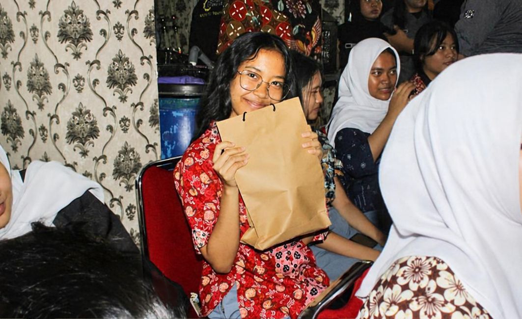 Apresiasi Keaktifan Siswa dalam Sesi Tanya Jawab Edukasi EBT Siswi SMAN 62 Jakarta memegang bingkisan apresiasi kegiatan edukasi energi bersih