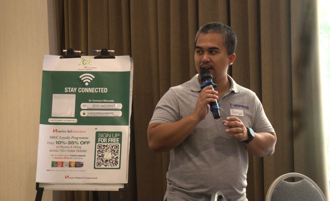 Fasilitator Patrya Pratama Memandu Sesi Interaktif Bootcamp GEMA Patrya Pratama memegang mikrofon memberikan arahan pada pelatihan guru di Bandung