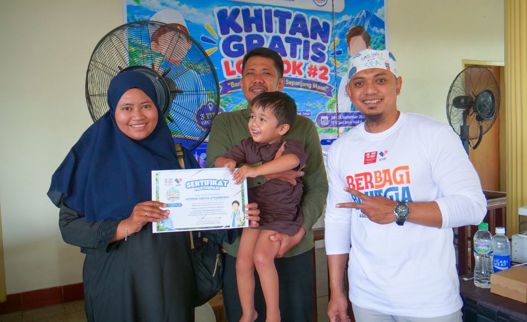 Anak peserta khitan gratis tersenyum memegang sertifikat kelulusan bersama orang tua dan relawan di Lombok